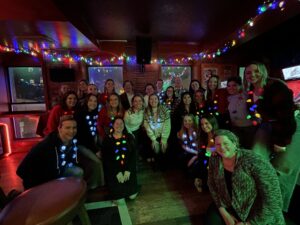 Group poses in dark room wearing festive, holiday apparel